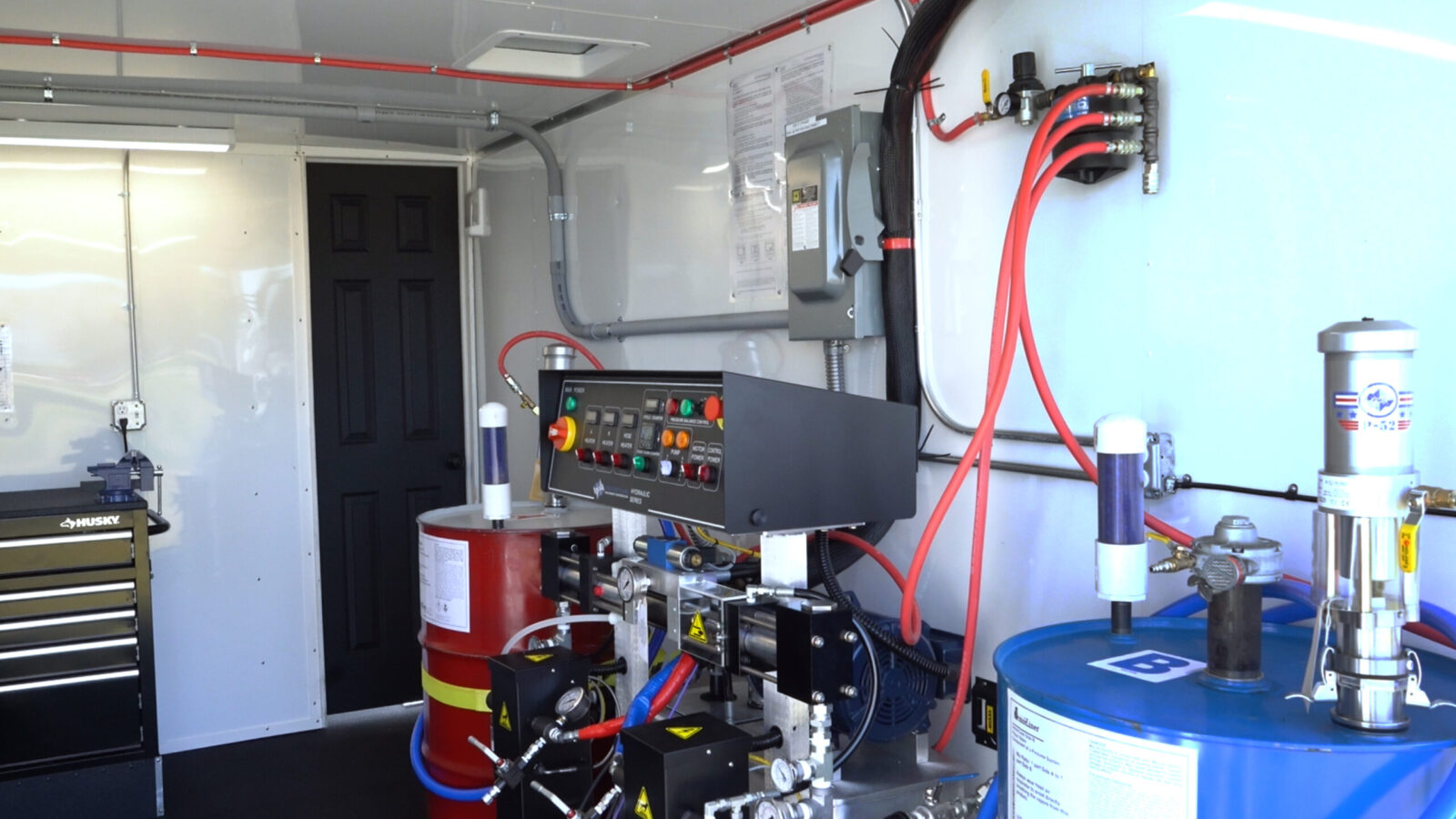 Inside an ArmorThane mobile coatings unit with proportioner and material drums