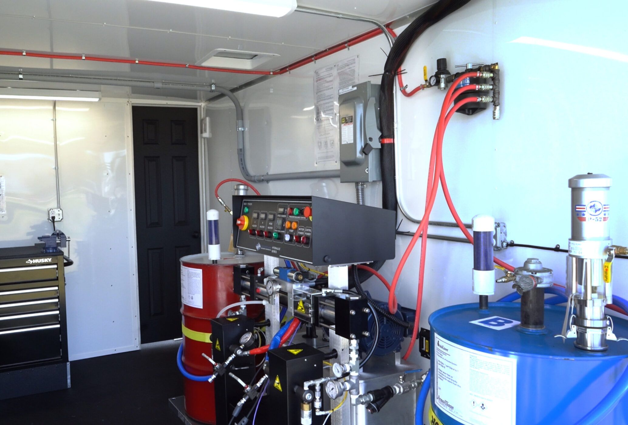 Inside an ArmorThane mobile coatings unit with proportioner and material drums