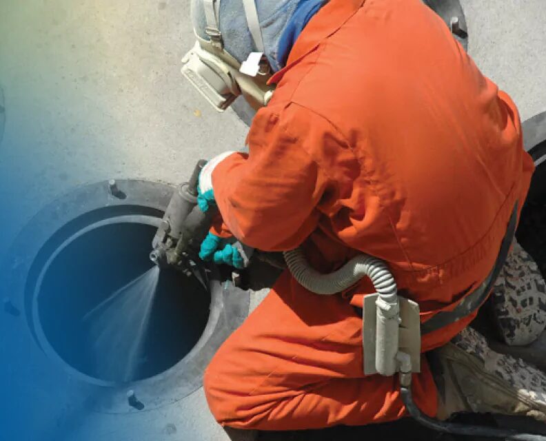 Applicator spraying a manhole barrel