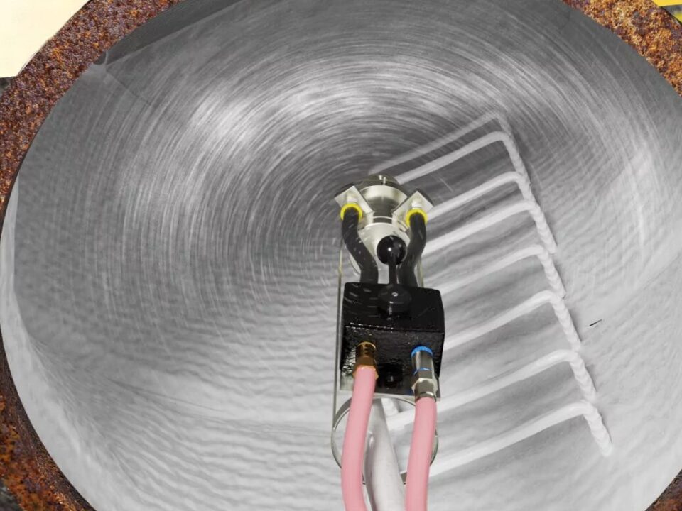 Top-down view of a manhole being lined with polyurea
