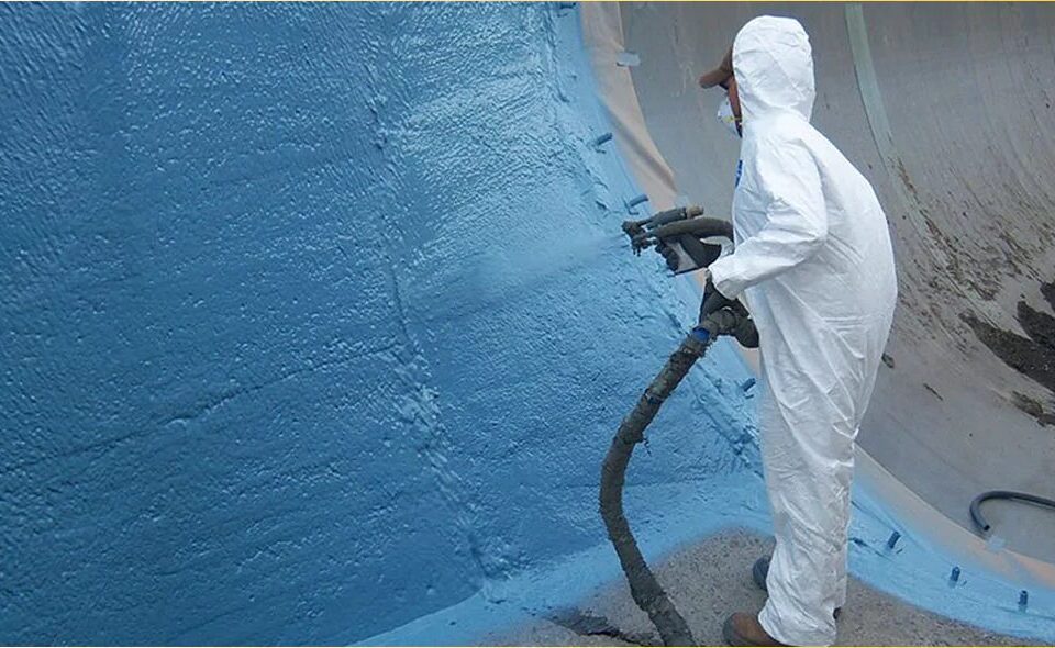 Applicator in protective suit spraying polyurea on a tank wall